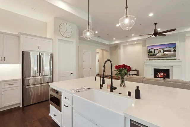 a kitchen with a sink stainless steel appliances and a chandelier