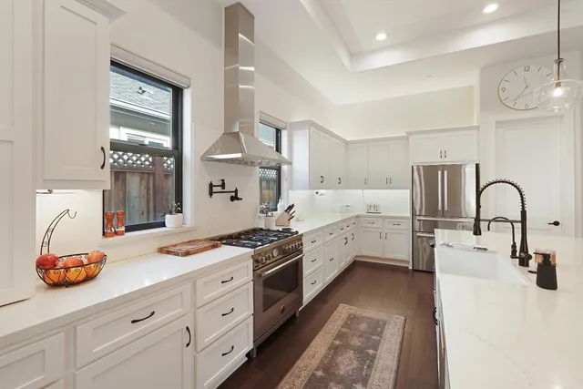 a kitchen with stainless steel appliances kitchen island a stove a sink and a refrigerator
