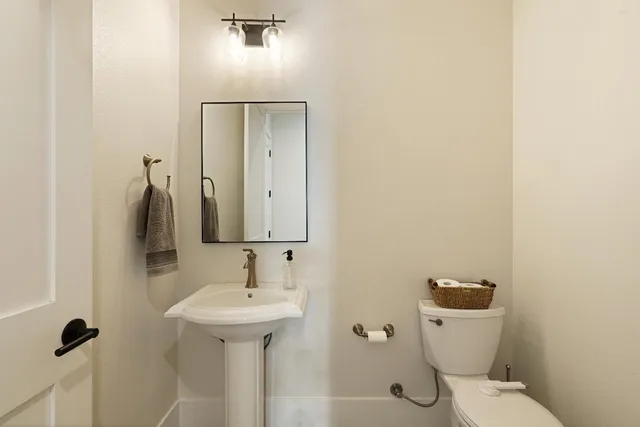 a bathroom with a sink a toilet and mirror