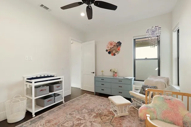 a room with a baby bed furniture and a window