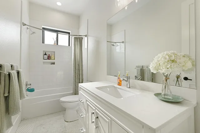 a bathroom with a sink a toilet and shower