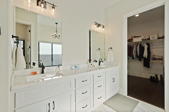 a bathroom with double vanity sink and a mirror
