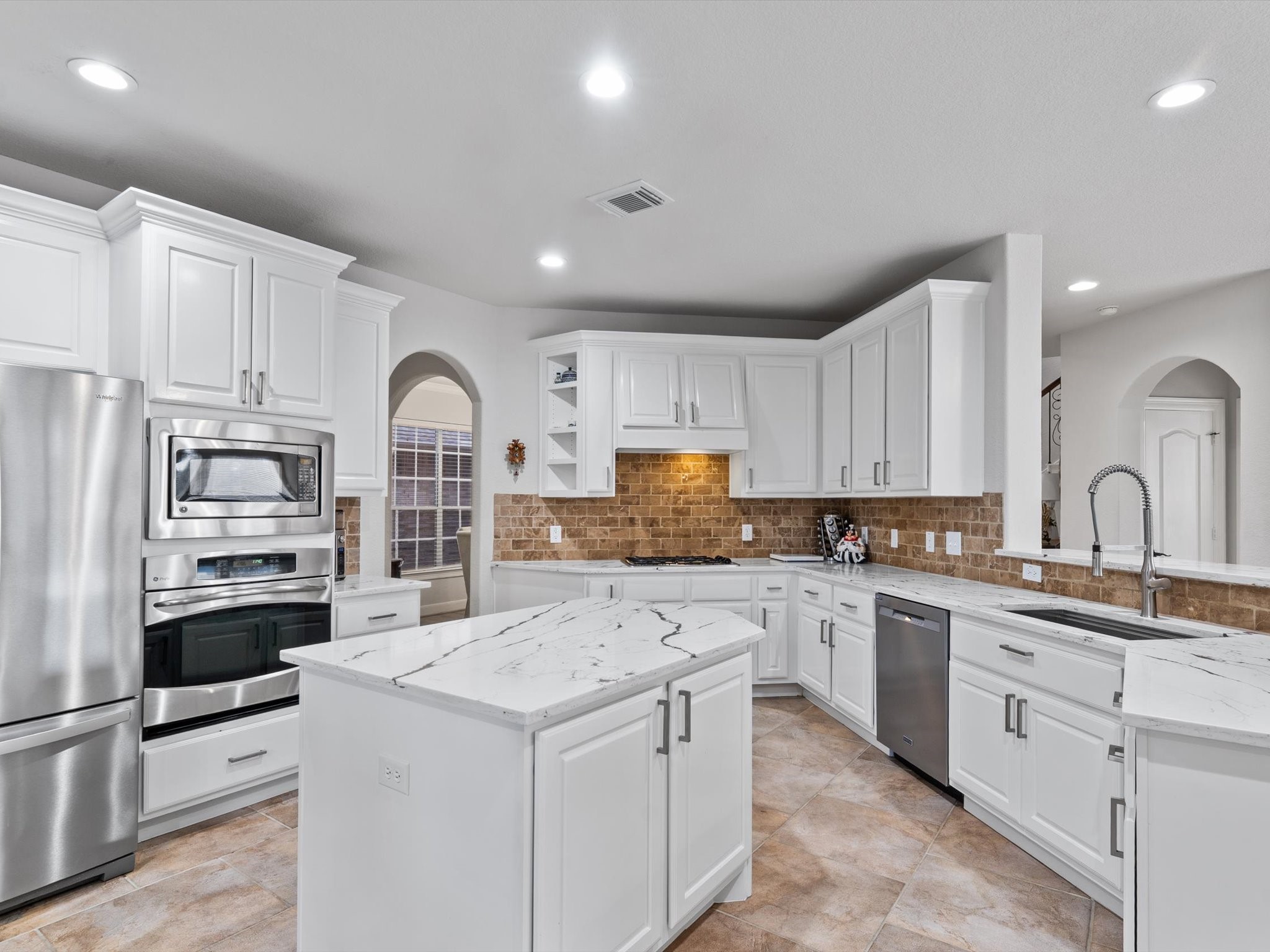 6003 Tarra Firma Drive Spring, TX 77379 - Photo 13 of 43 Gourmet island kitchen features premium quartz countertops updated cabinetry and high-end stainless appliances. Open-concept design ensures the chef is always part of the conversation.