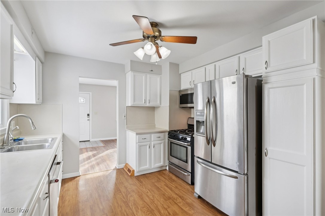 611 Wilson Street Struthers, OH 44471 - Photo 3 of 44 Kitchen featuring appliances with stainless steel finishes, white cabinetry, light wood-type flooring, and light countertops