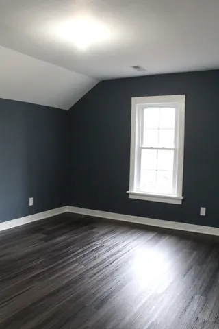 a view of a small space with wooden floor and a window