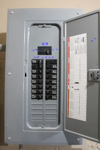 a view of a house with a small deck and a large tree