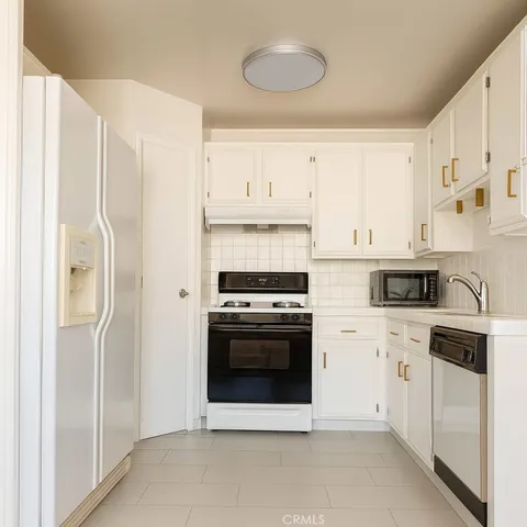 a kitchen with cabinets stainless steel appliances and a counter space