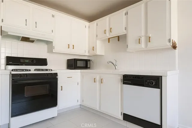 a view of a kitchen with white cabinets