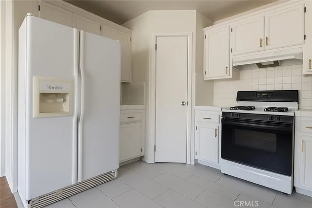 a kitchen with stainless steel appliances white cabinets and a refrigerator