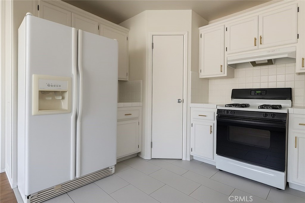 18619 Collins Street, Unit F29 Tarzana, CA 91356 - Photo 6 of 29 a kitchen with stainless steel appliances white cabinets and a refrigerator