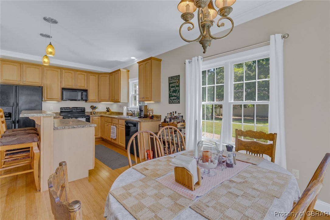 189 Virginia Road Reedville, VA 22539 - Photo 12 of 46 Dining area with a chandelier, light wood finished floors, and crown molding