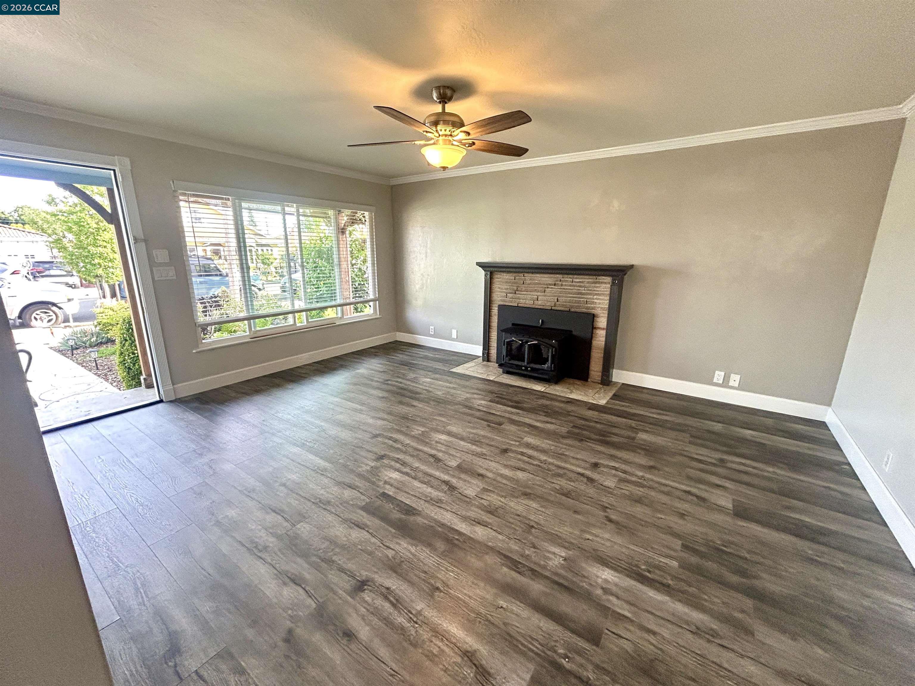 356 Frederic Avenue Hayward, CA 94544 - Photo 2 of 10 an empty room with wooden floor fireplace and windows