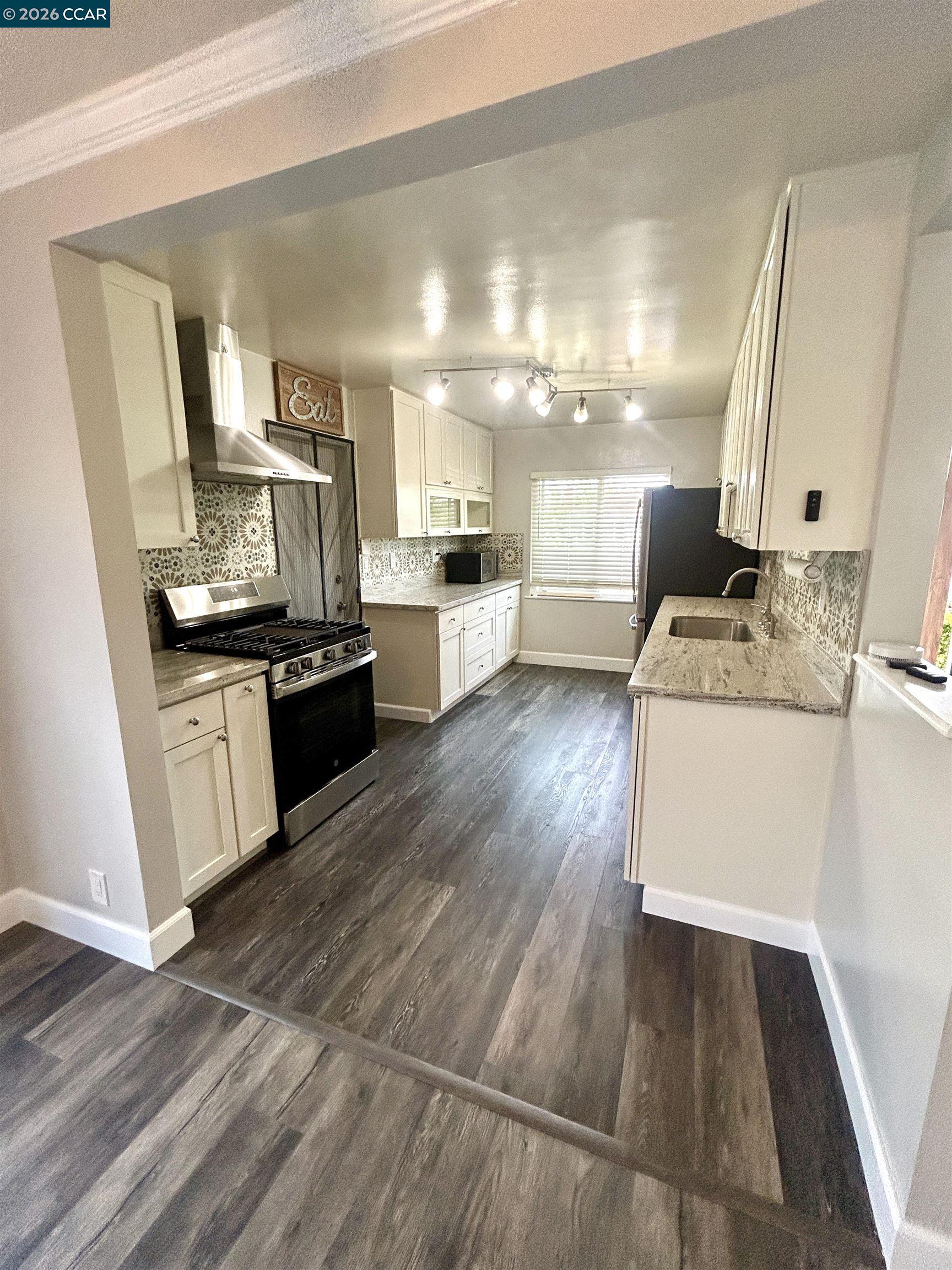356 Frederic Avenue Hayward, CA 94544 - Photo 5 of 10 a view of a kitchen with a sink wooden floor and a window
