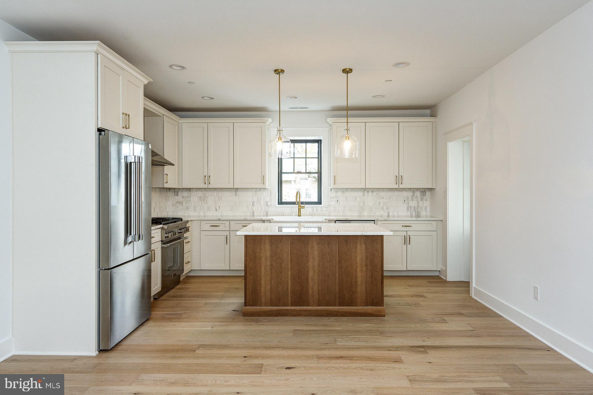 20 East Redman Avenue, Unit D Haddonfield, NJ 08033 - Photo 12 of 43 a kitchen with stainless steel appliances granite countertop a refrigerator a sink dishwasher a stove and white countertops with wooden floor