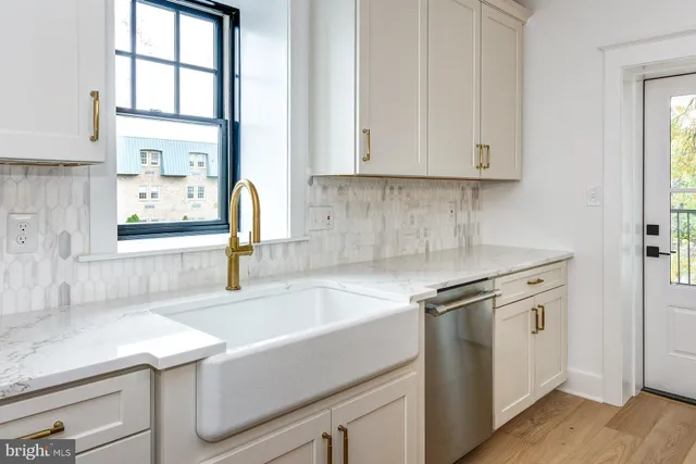 a kitchen with granite countertop a sink and a stove with white countertops