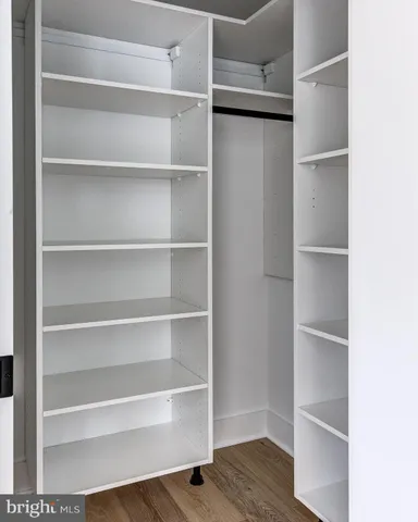 a view of walk in closet with empty racks