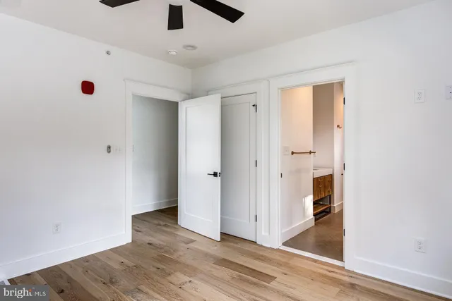 a view of an empty room with wooden floor and windows