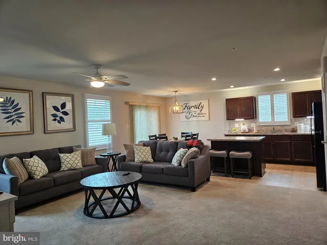 a living room with furniture and view of kitchen
