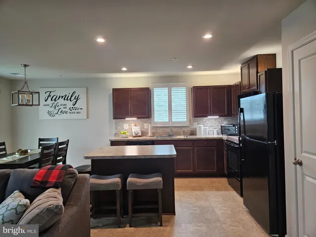 a kitchen with refrigerator and chairs