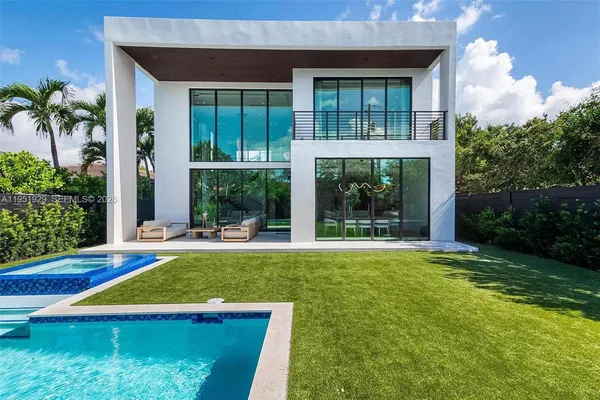 a view of swimming pool with lawn chairs and plants