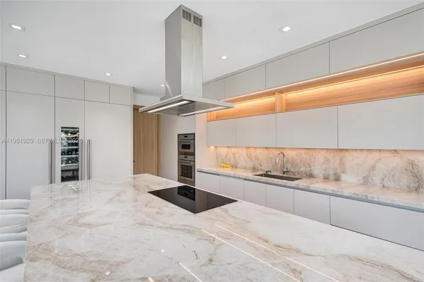 a large kitchen with a large counter top and stainless steel appliances