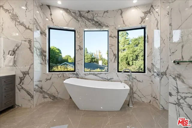 a bedroom with a balcony a bed and a dresser