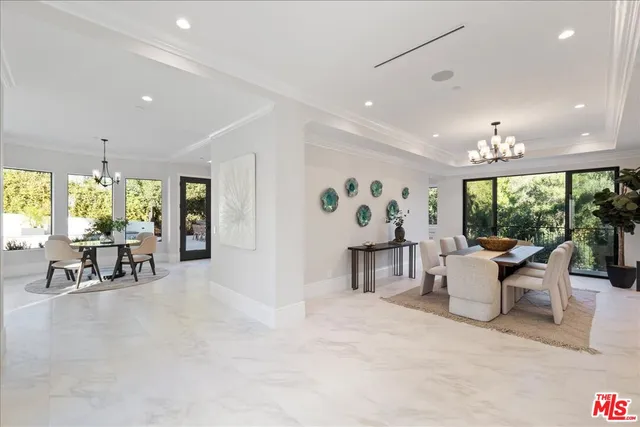 a living room with furniture chandelier and a large window