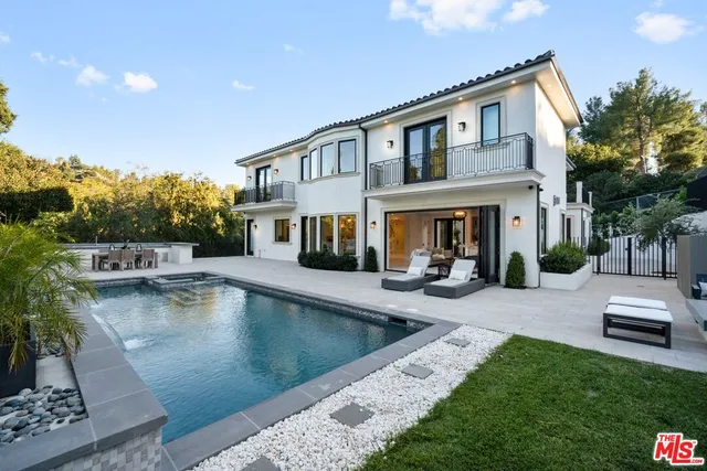 a kitchen with a dining table chairs stove and white cabinets