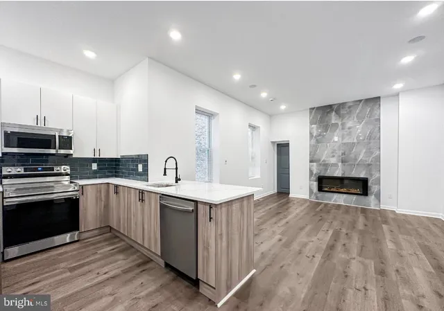 a large kitchen with stainless steel appliances granite countertop a stove and a sink