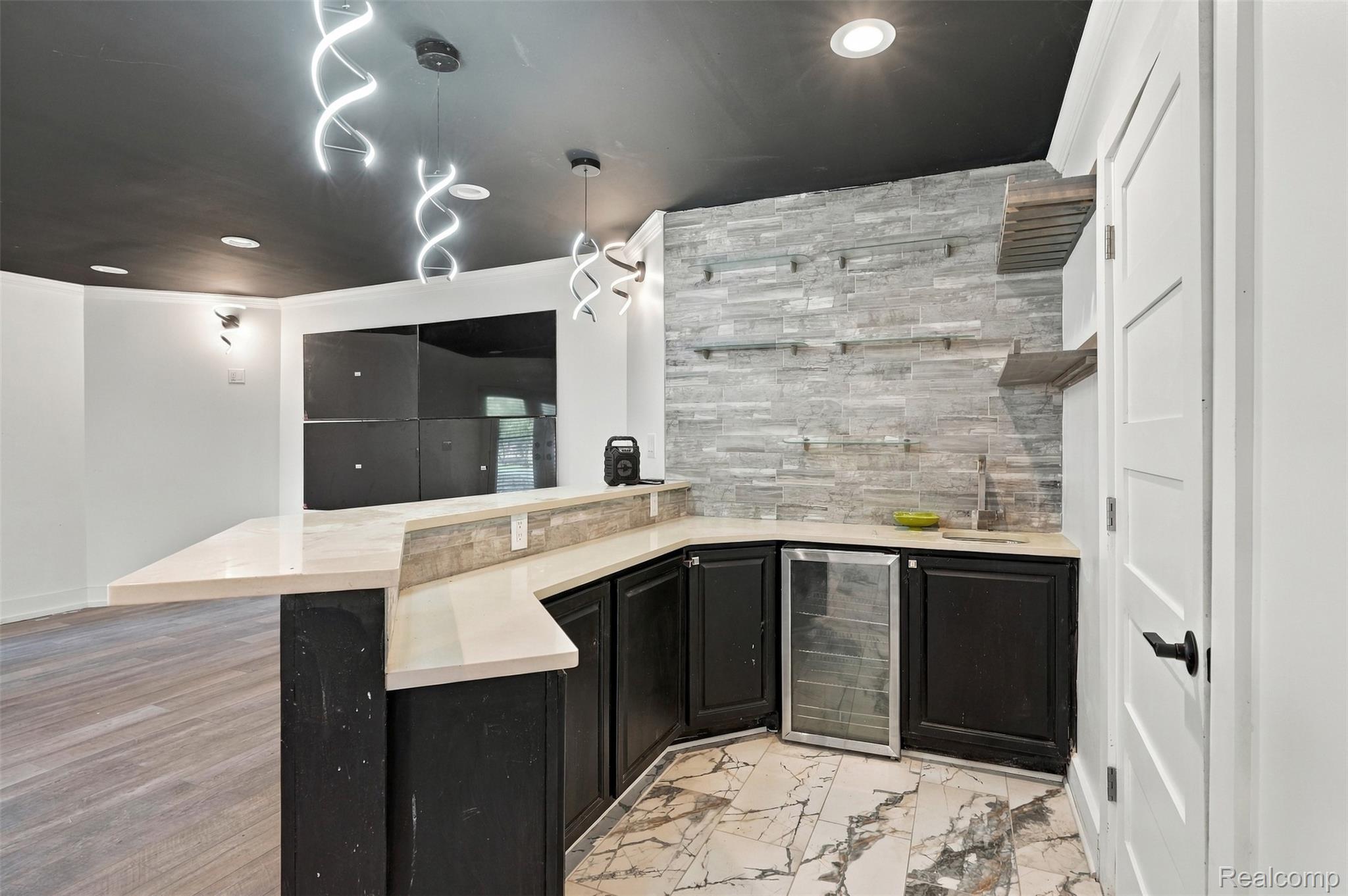 27507 Bell Road Southfield, MI 48034 - Photo 48 of 81 Wet bar featuring a beverage cooler, black cabinetry, and light-toned countertops