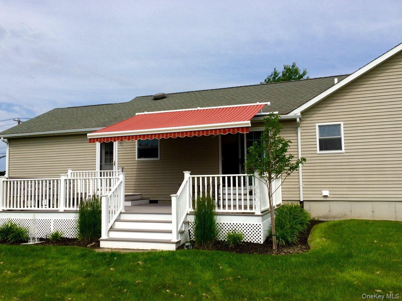 312 Riley Avenue Baiting Hollow, NY 11933 - Photo 23 of 31 Multi-level outdoor deck featuring white railings and an retractable red and white striped awning