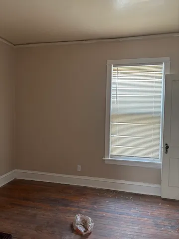 a view of a small space with wooden floor and a window