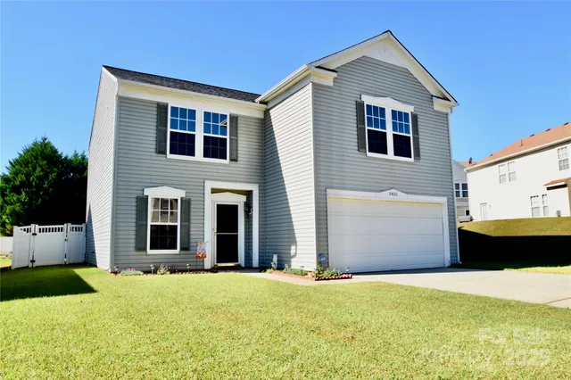 a front view of house with yard and garage