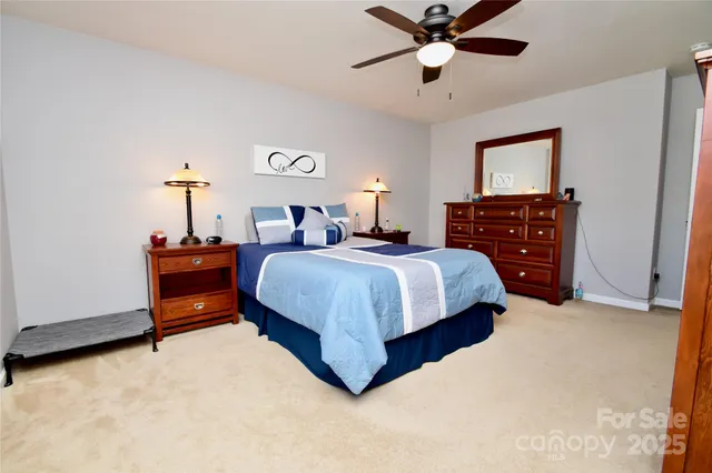 a bed room with a bed and a ceiling fan