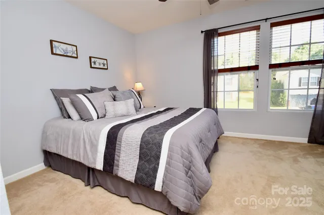 a bedroom with a bed and a large window