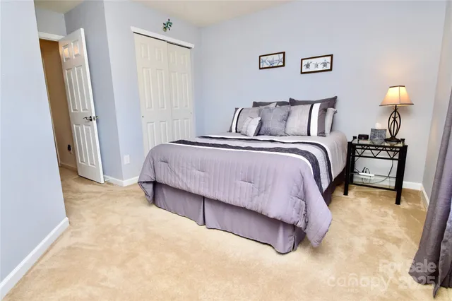 a spacious bedroom with a bed and a lamp with window