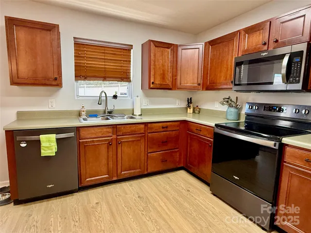 a kitchen with stainless steel appliances granite countertop a sink stove and microwave