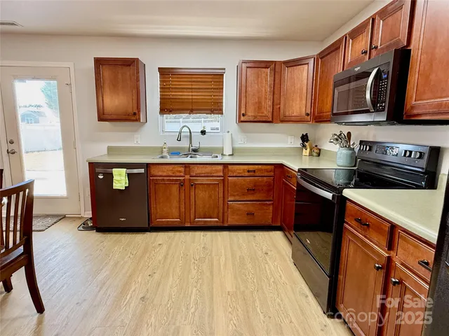 a kitchen with stainless steel appliances granite countertop wooden cabinets a stove top oven a sink and dishwasher