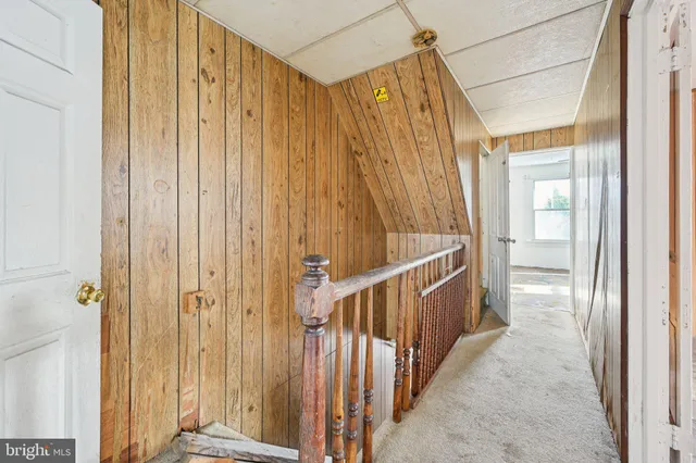 a view of an empty room with a window and hardwood floor