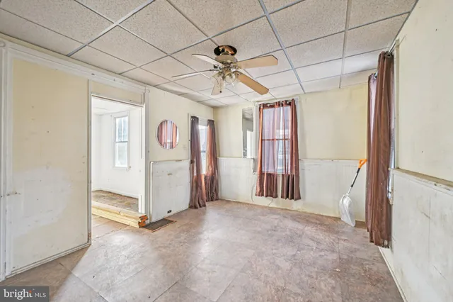 a view of a livingroom with a chandelier fan and windows