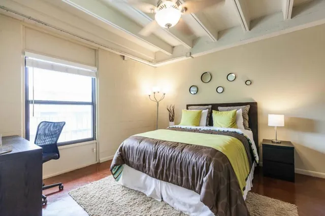 a bedroom with a bed and wooden floor