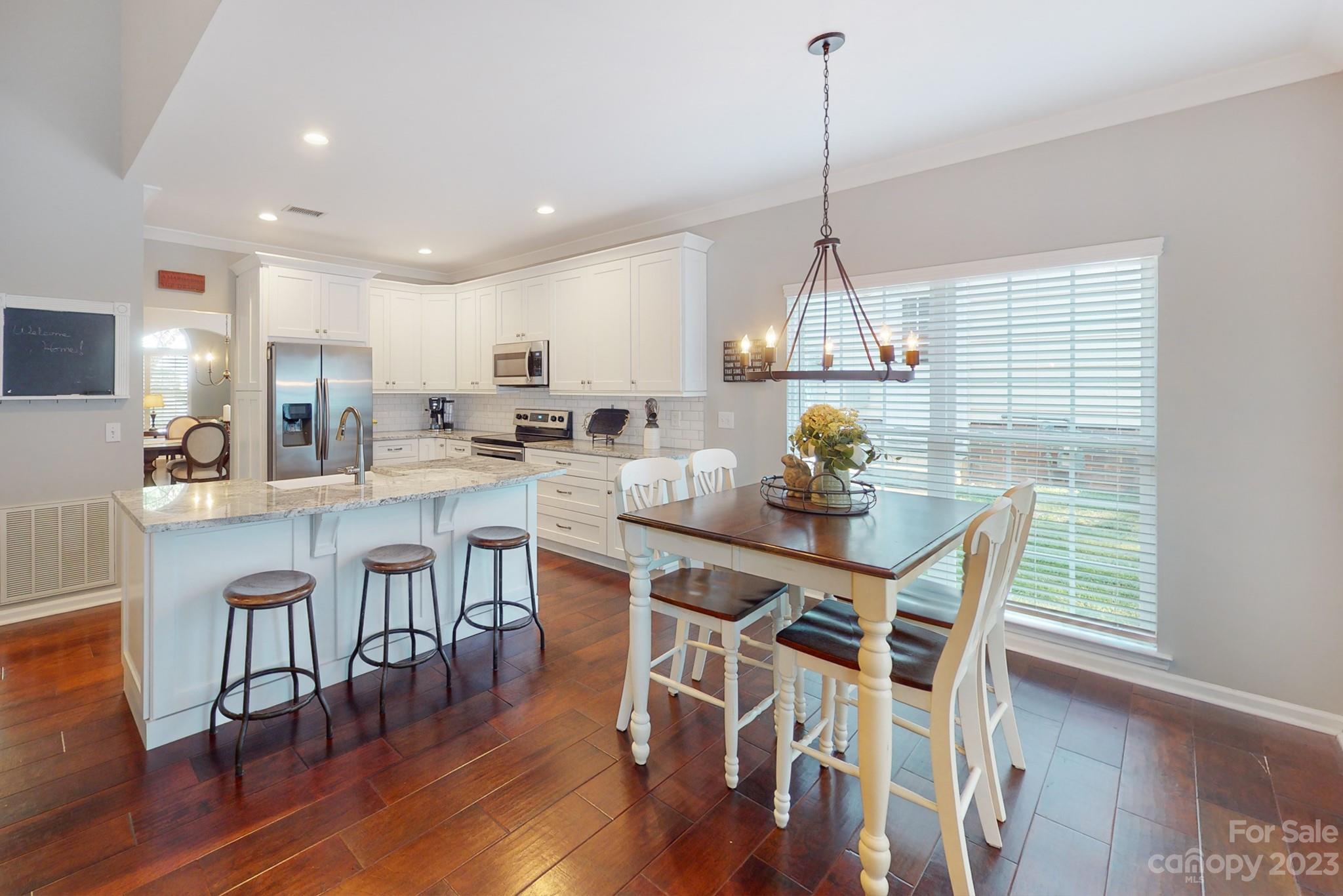 16022 Lavenham Road Huntersville, NC 28078 - Photo 11 of 35 a kitchen with stainless steel appliances a dining table chairs refrigerator and sink