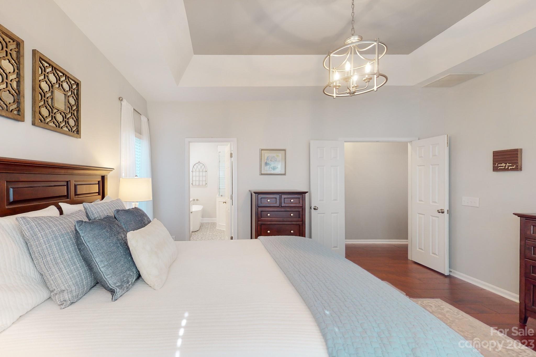 16022 Lavenham Road Huntersville, NC 28078 - Photo 18 of 35 a spacious bedroom with a bed and a chandelier