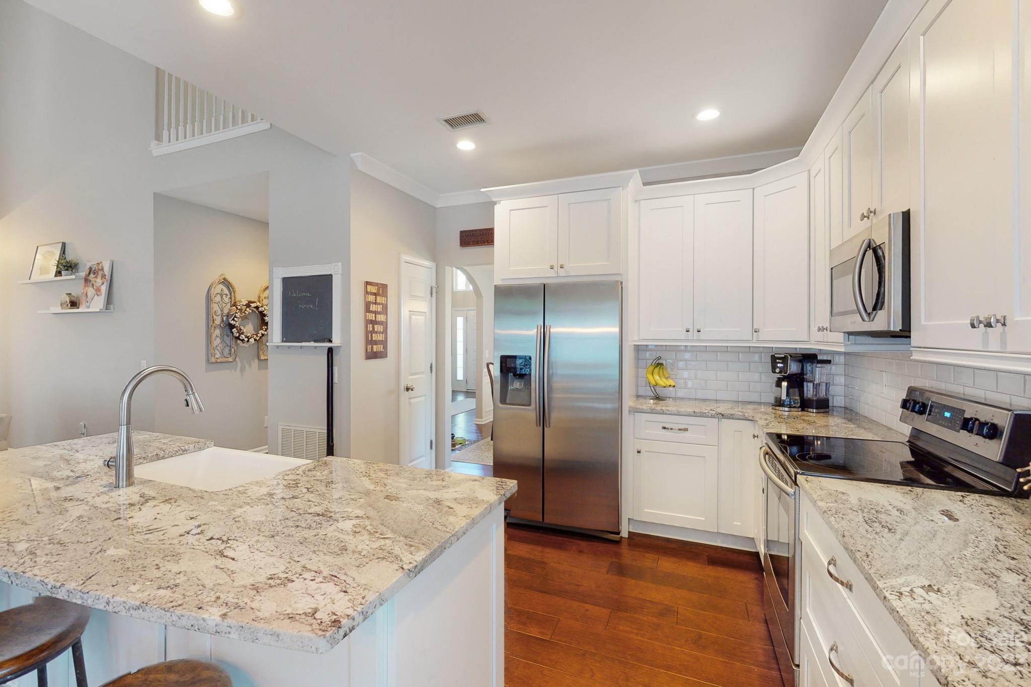 16022 Lavenham Road Huntersville, NC 28078 - Photo 10 of 35 a kitchen with stainless steel appliances granite countertop a refrigerator sink and cabinets