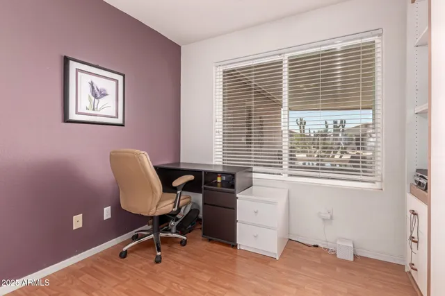 a view of a workspace with furniture and a window