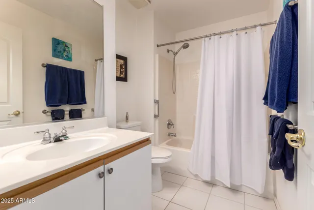 a bathroom with a sink a toilet and shower curtain