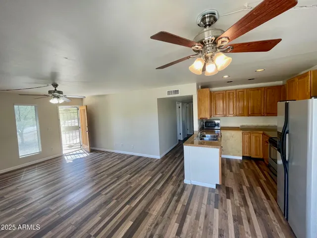 a kitchen with a wooden floor and a refrigerator