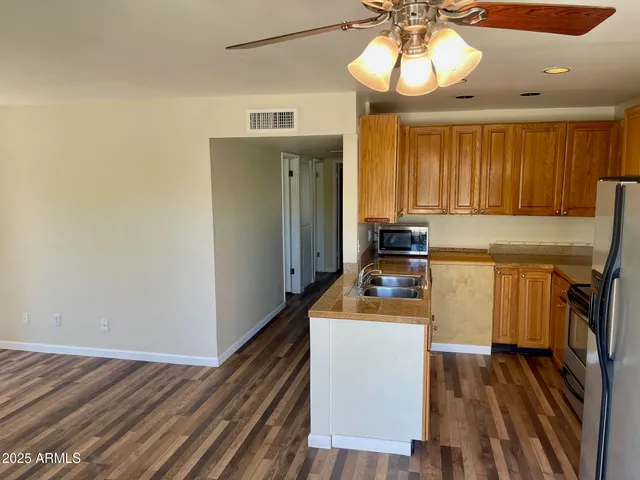 a kitchen with wooden floor and white appliances