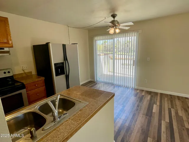 a kitchen with wooden floor a sink and a refrigerator