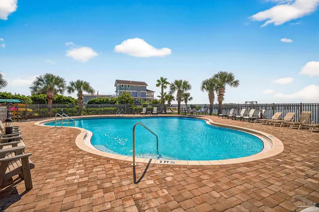 an empty room with chandelier fan and windows